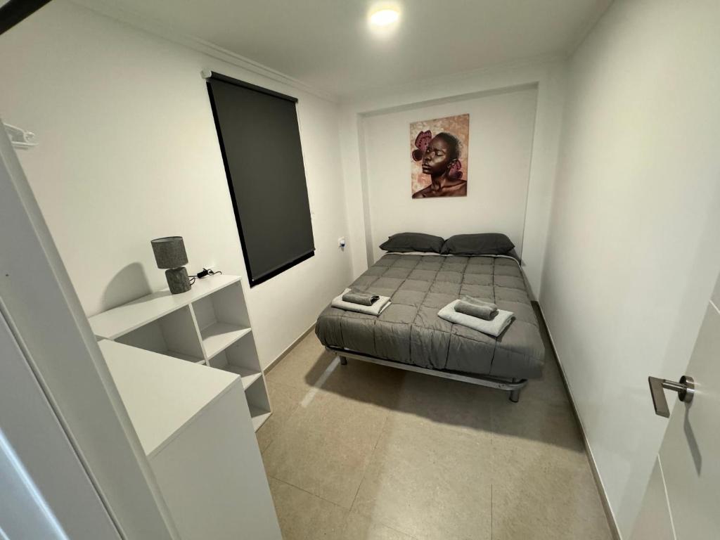 1 dormitorio con 1 cama en una habitación pequeña en Piso nuevo al lado del mar, en Valencia