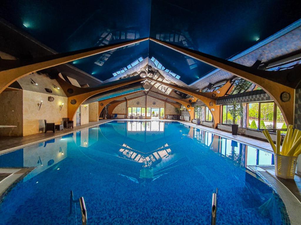 a large swimming pool in a building with a ceiling at Bellacya Resort & Spa in Sovata