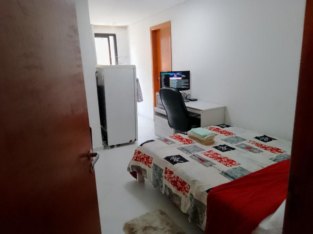een kamer met een bed en een bureau met een computer bij Studio Gru in Guarulhos