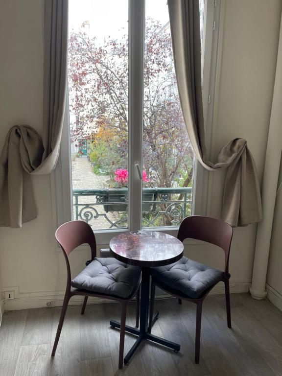 une table et deux chaises devant une fenêtre dans l'établissement Renovated ! City of Lights, light your visit, à Paris