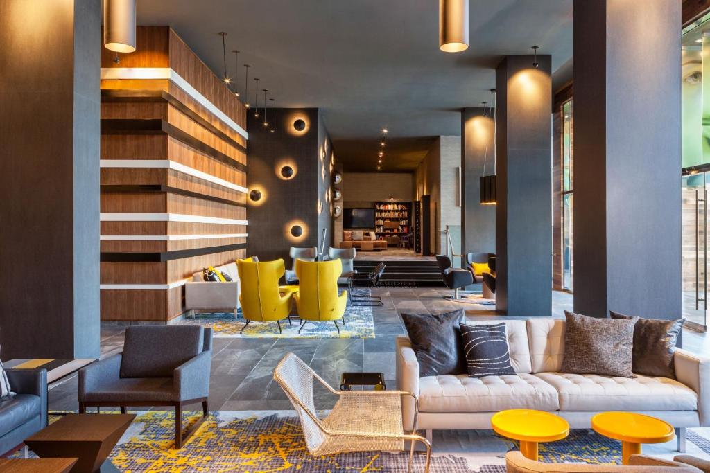 a lobby with couches and chairs and a staircase at Le Méridien Charlotte in Charlotte