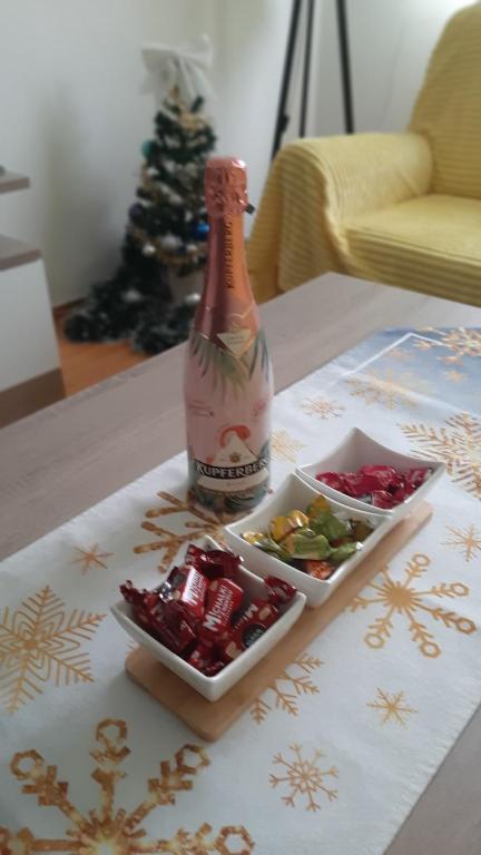 a bottle of champagne and a bowl of candy on a table at Apartman Vule in Pale