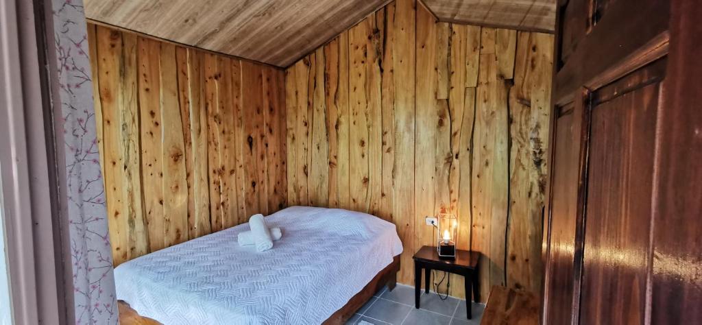 a bedroom with a bed in a wooden wall at Mora's Place B&B in Monteverde Costa Rica