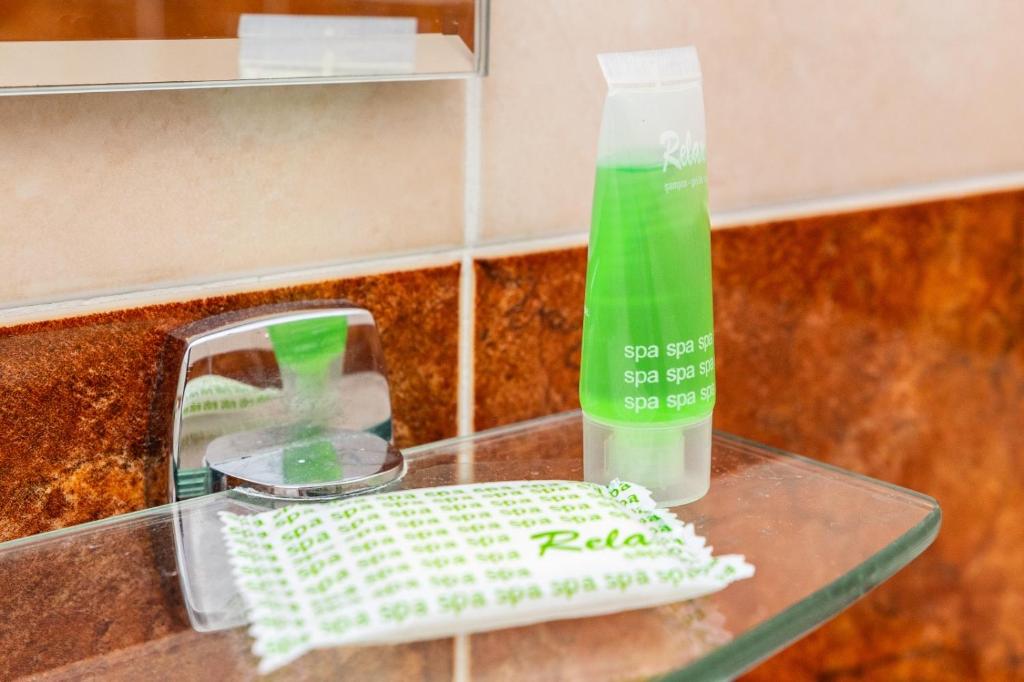 a bottle of green liquid sitting on top of a counter at Pensiunea Luca in Şirnea