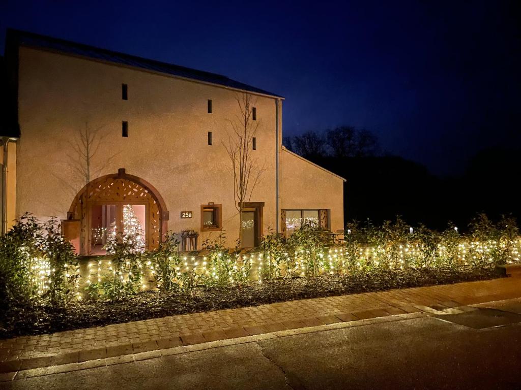 una recinzione coperta di luci di fronte a un edificio di Scheier (Ferienwohnungen) a Perl