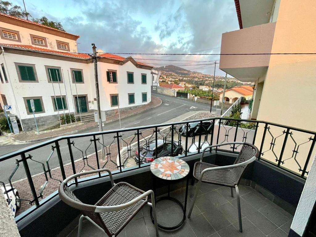 a balcony with chairs and a table and a street at Mountain View Star in Estreito da Calheta
