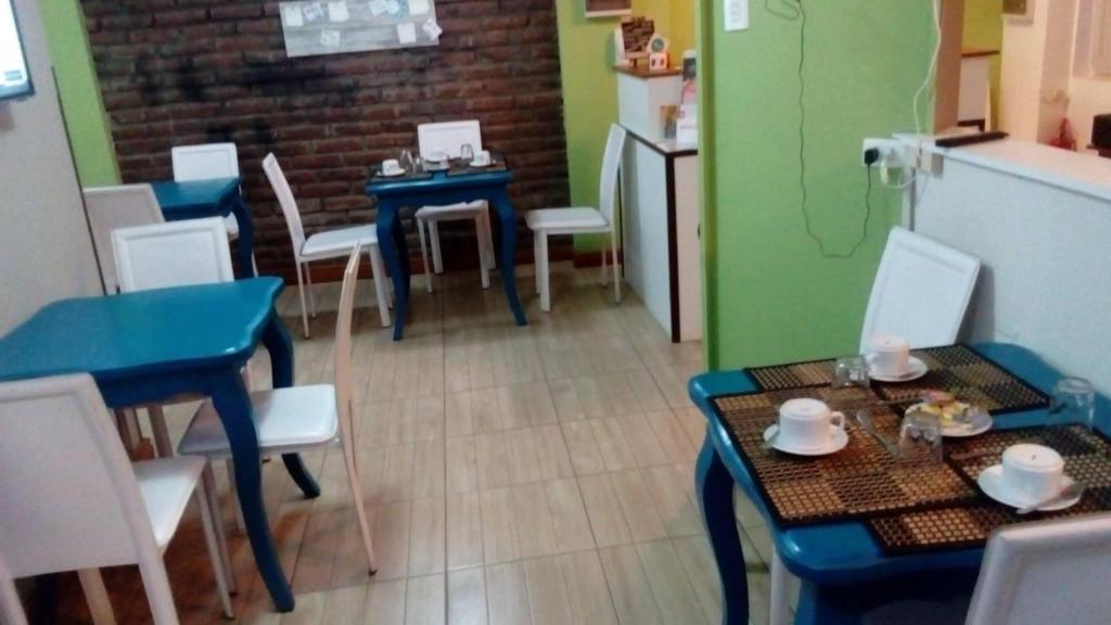 a room with tables and chairs and a kitchen at Hostal Casa Alegre in Valparaíso