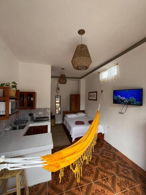a room with a bed and a hammock in it at El Encanto de Mimi in Puerto Ayora