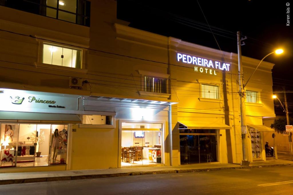 ein Geschäft vor einem Hotel in der Nacht in der Unterkunft PEDREIRA FLAT HOTEL in Pedreira