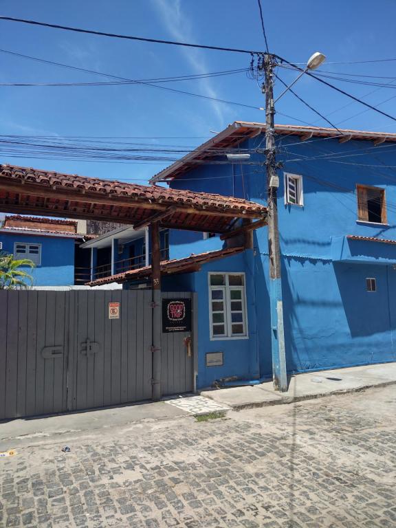 un edificio azul con una valla delante en Suítes good trip itacare en Itacaré