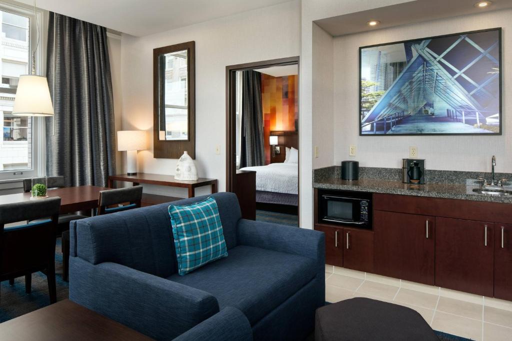 a living room with a blue couch in a hotel room at Courtyard Seattle Downtown / Pioneer Square in Seattle