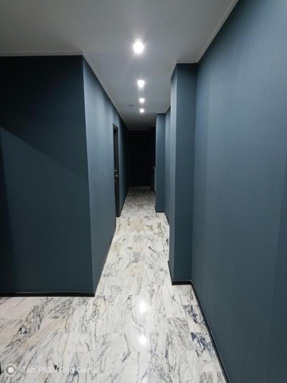 einen Flur mit blauen Wänden und Marmorboden in der Unterkunft Blu room in Taranto