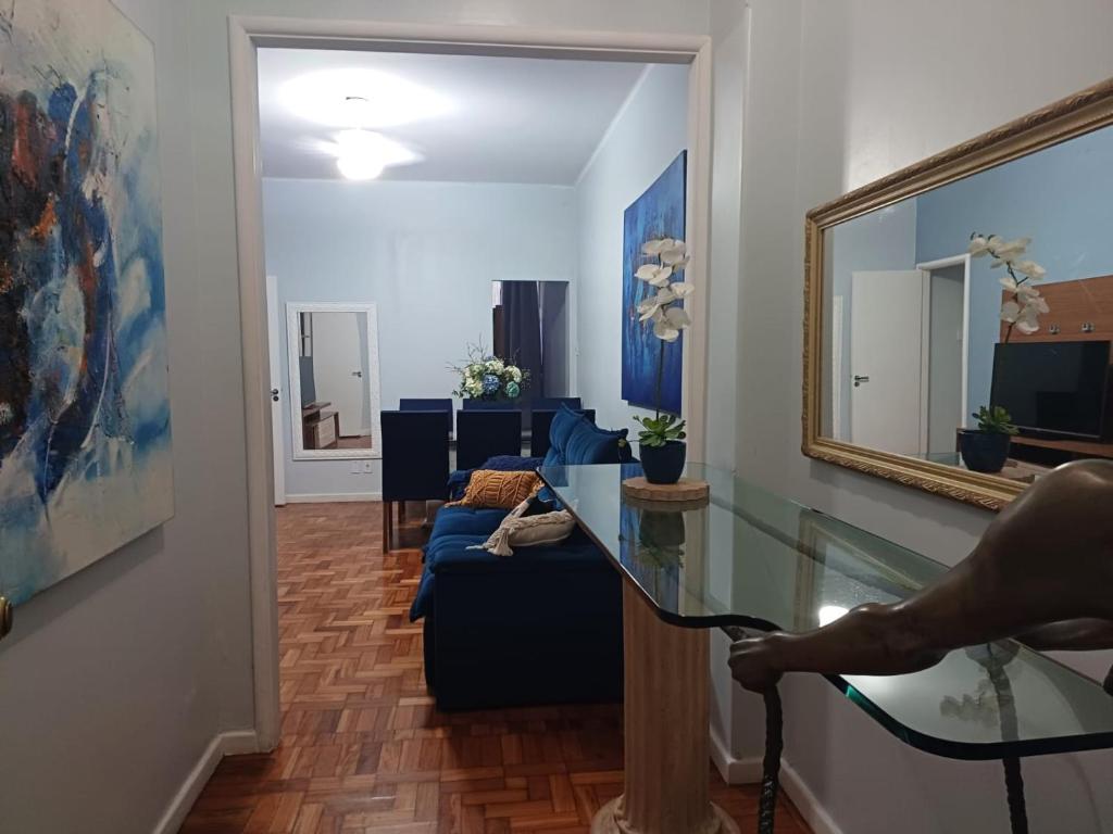 uma sala de estar com um sofá azul e um espelho em Apartamento Copacabana Posto 5 no Rio de Janeiro