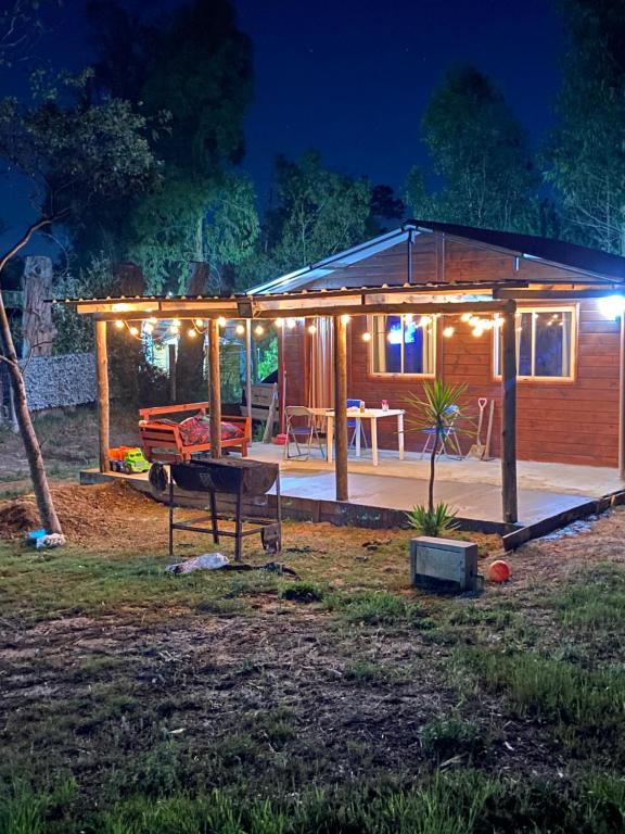 a small wooden house with a patio at night at maripe in Balneario Argentino