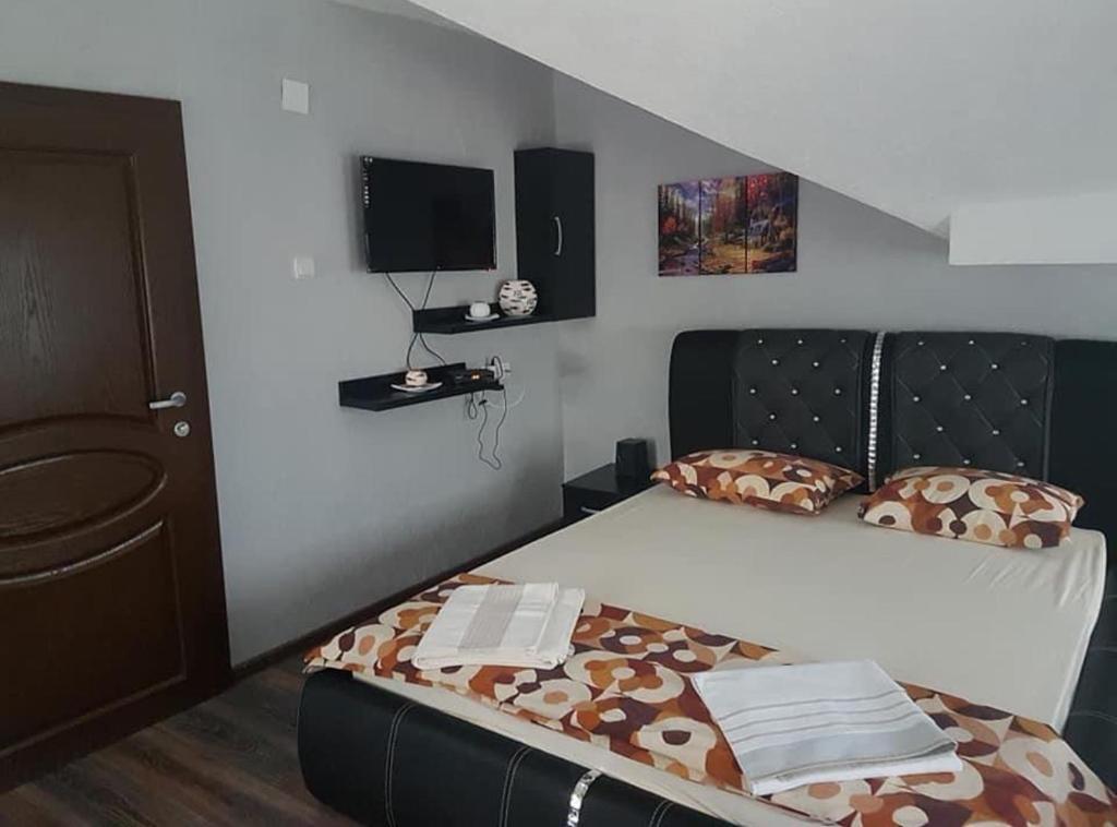a bedroom with a bed with a black head board at Villa Tino Omorani in Veles