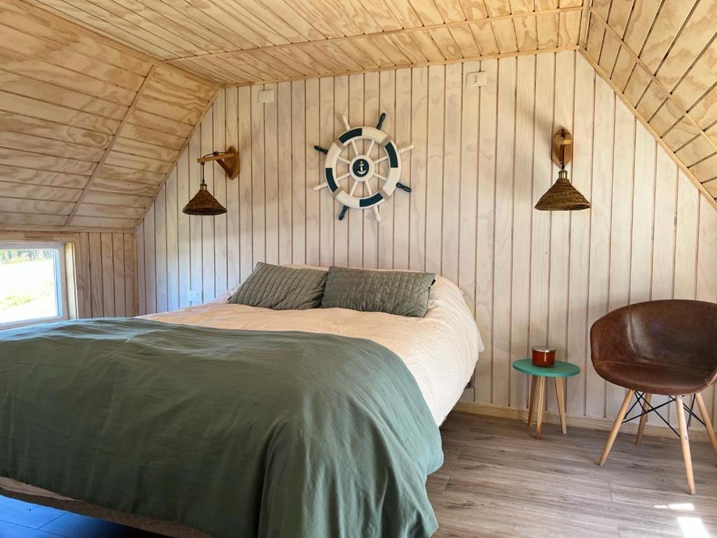 a bedroom with a bed and a fan on the wall at Dalcahue Lodge 