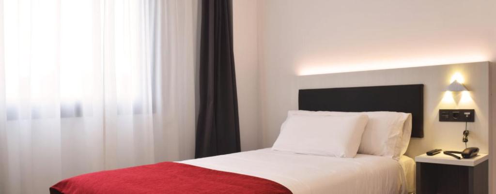 a hotel room with a bed with a red blanket at Santa Limbania Boutique Hotel in Santa Cruz de la Sierra