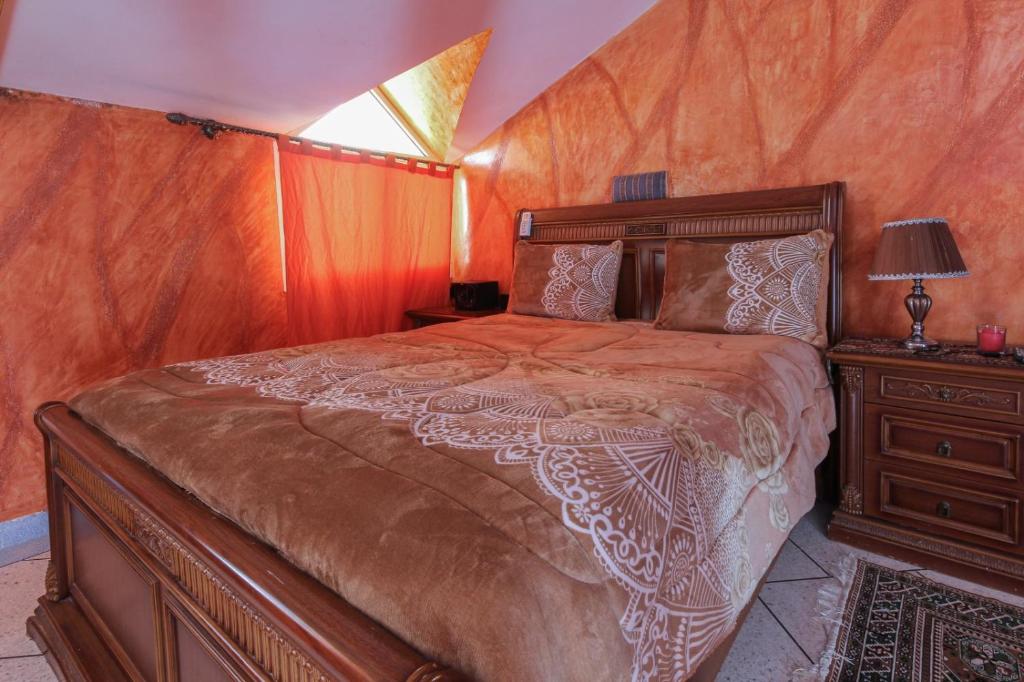 um quarto com uma cama grande e uma mesa de cabeceira em Chambre familiale em Aït Mouloud