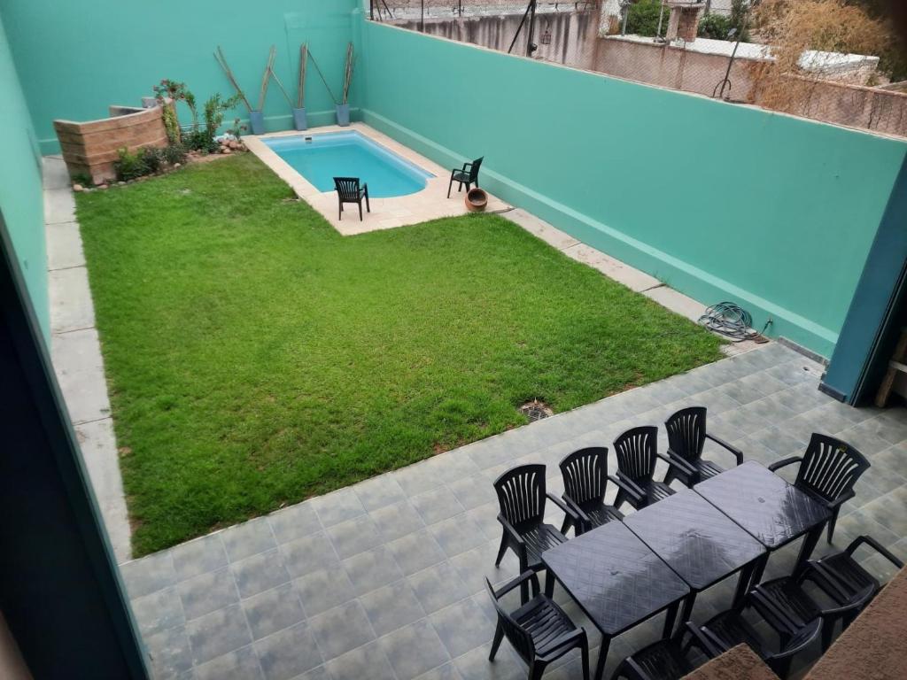 un patio con mesa y sillas junto a una piscina en MODERNA x 11 Pax en Mendoza