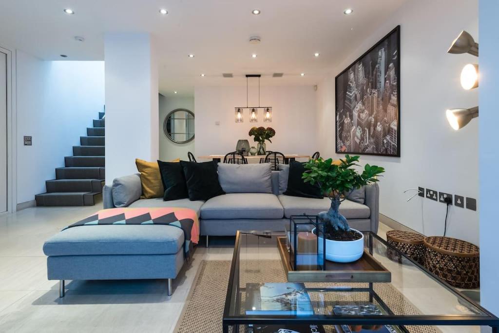 uma sala de estar com um sofá e uma mesa em Spectacular Mews House in Holland Park em Londres