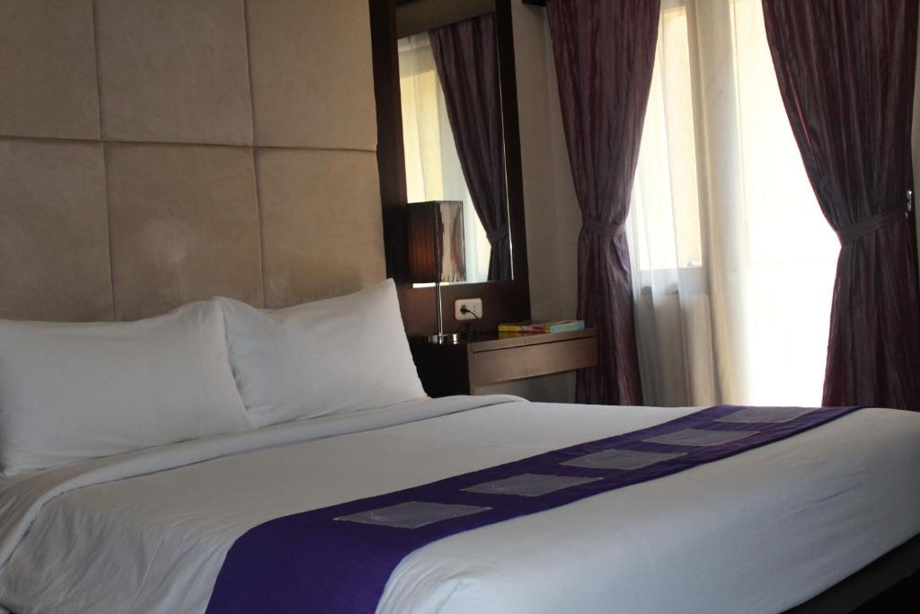 Postel nebo postele na pokoji v ubytování Metro Hotel Jababeka
