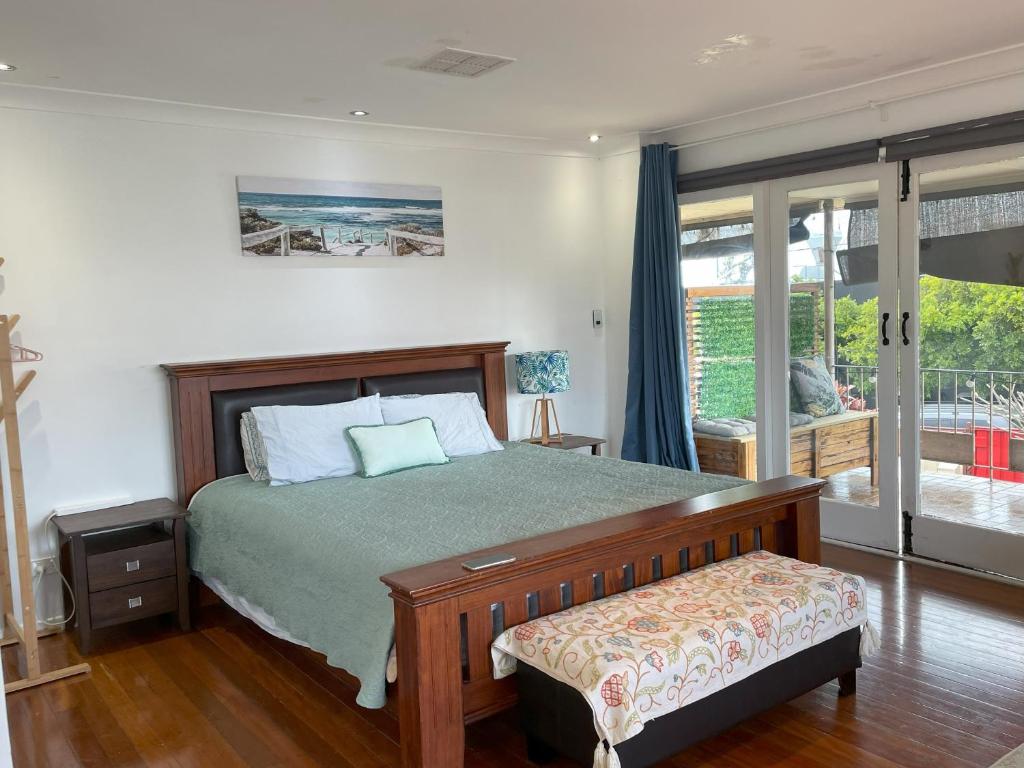 a bedroom with a bed and a sliding glass door at Romantic Escape/ Cozy Delight in Brisbane