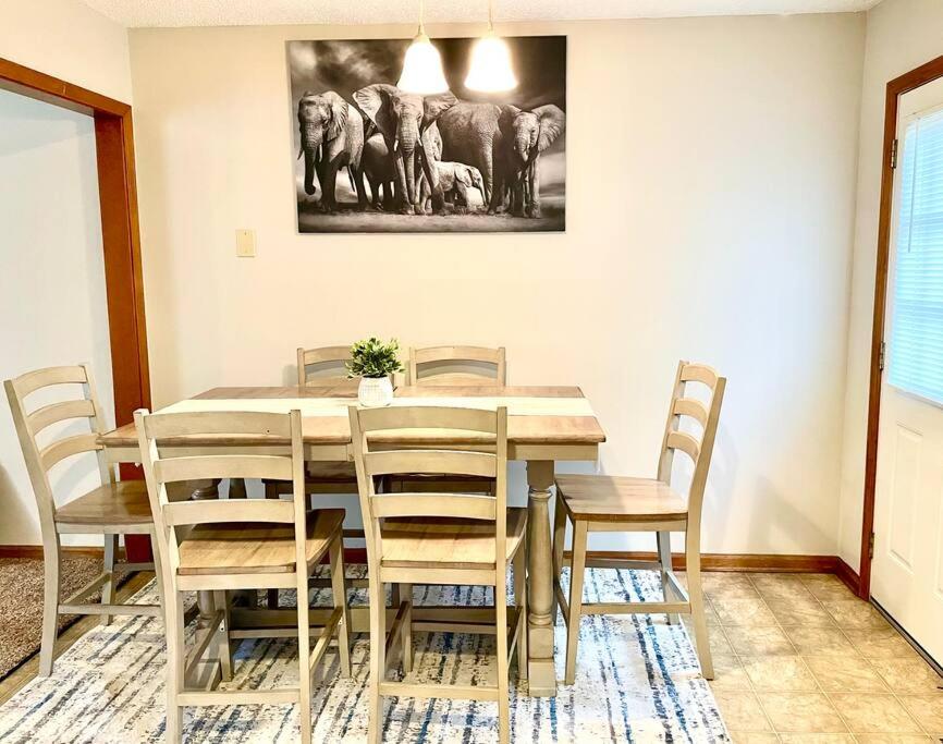 uma mesa de jantar com cadeiras e uma pintura de elefantes em Beautiful and Cozy Olathe Home. em Olathe
