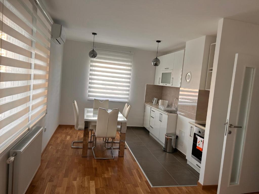 eine Küche mit einem Tisch und Stühlen im Zimmer in der Unterkunft Apartman Vrbas 1 + Podzemna garaza in Banja Luka