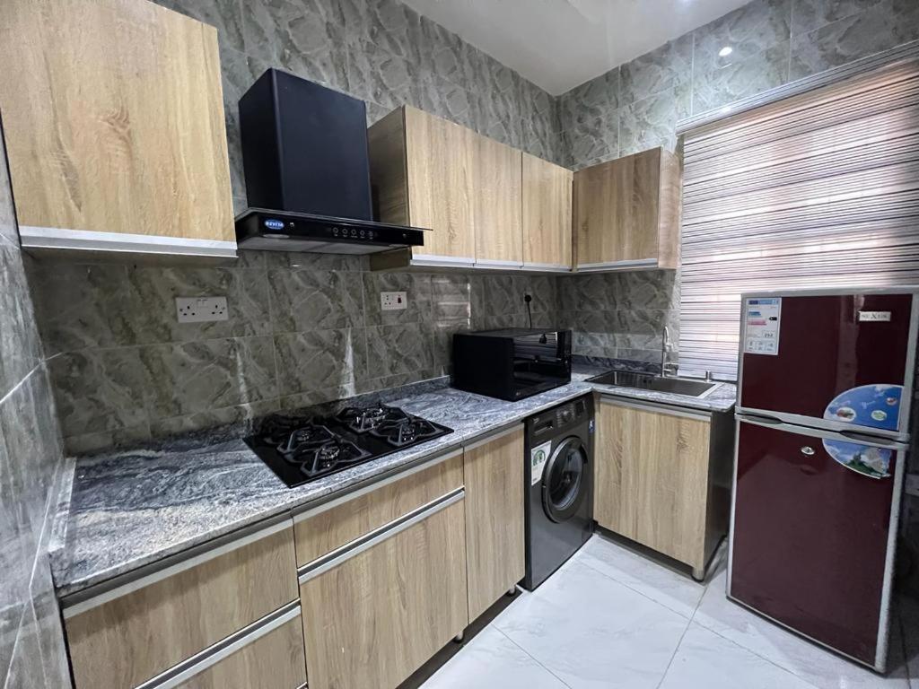 Il comprend une petite cuisine équipée d'une cuisinière et d'un réfrigérateur. dans l'établissement Oluyole Apartments Ibadan, à Ibadan