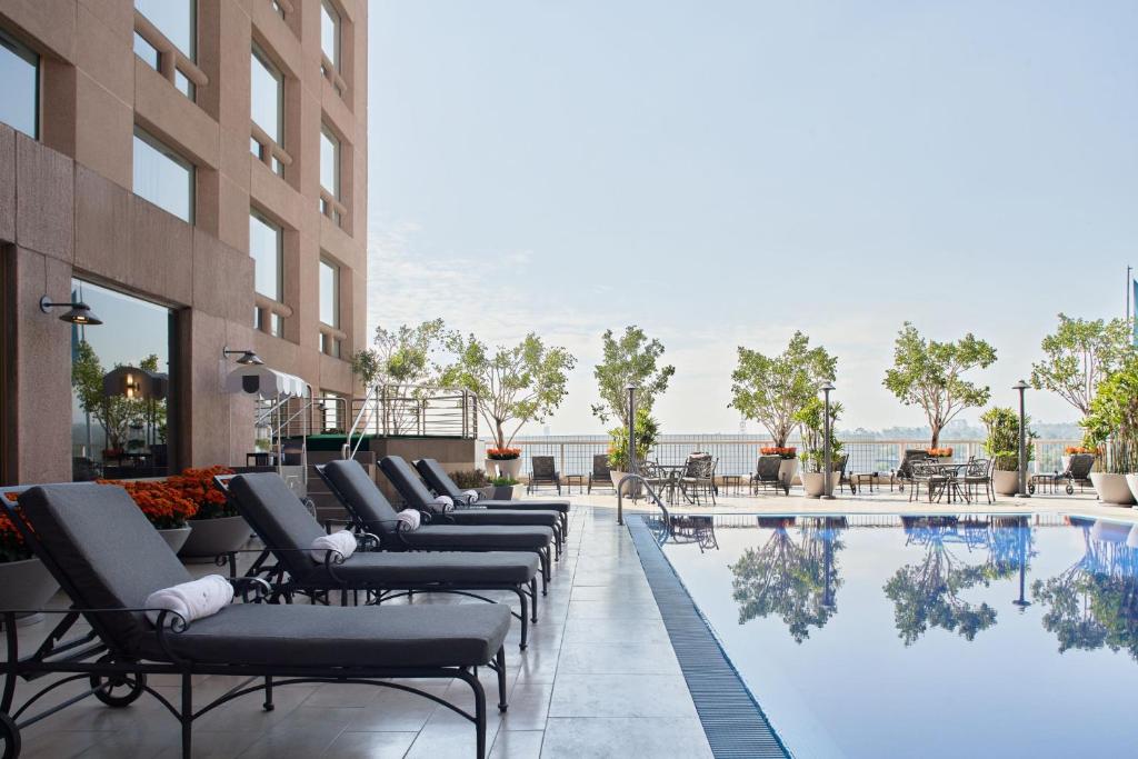 una piscina de hotel con tumbonas y mesas en JW Marriott Hotel Mexico City Polanco, en Ciudad de México