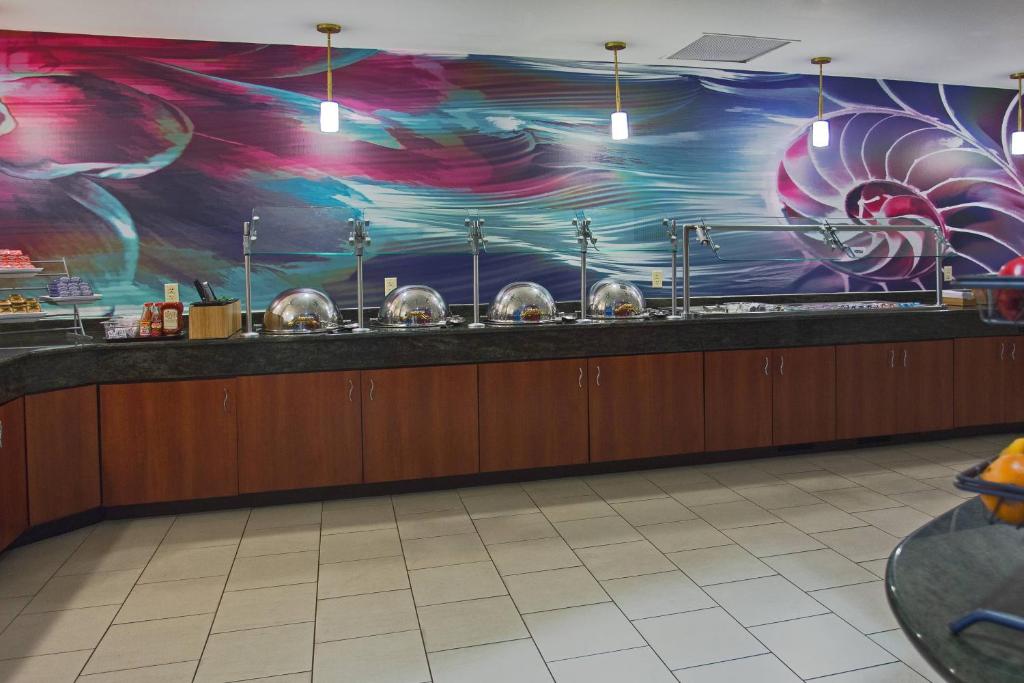 a restaurant kitchen with a mural on the wall at SpringHill Suites by Marriott Virginia Beach Oceanfront in Virginia Beach
