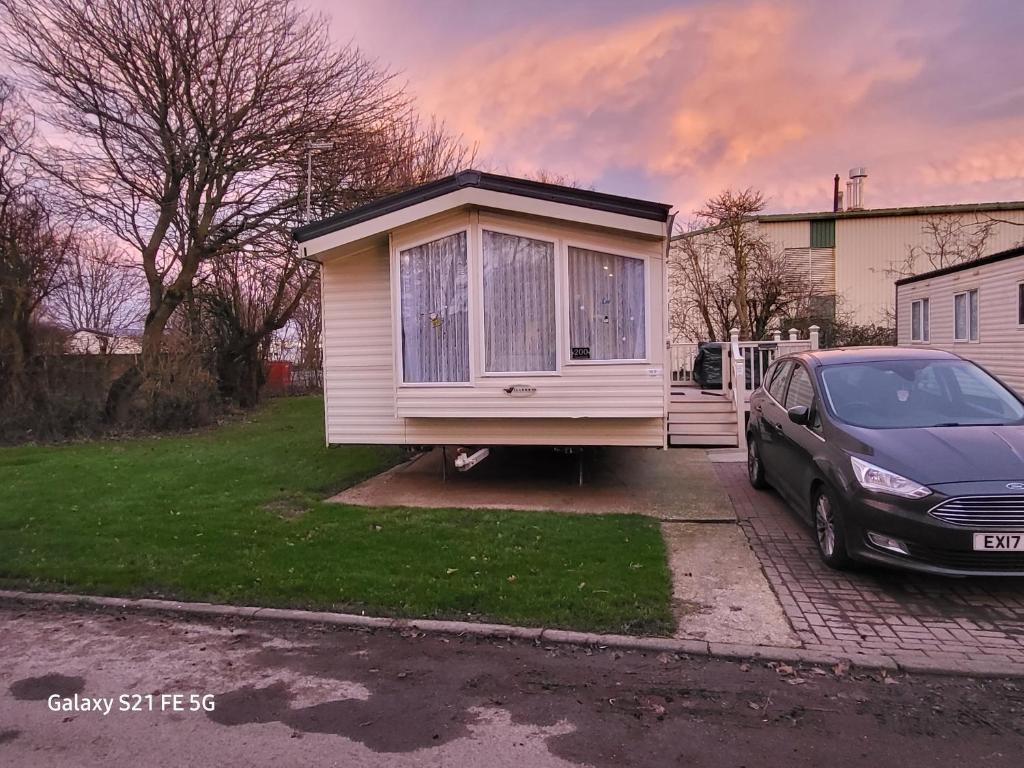 uma pequena casa estacionada numa garagem com um carro em westfield200-Immaculate 2Bed Static at Skipsea em Barmston