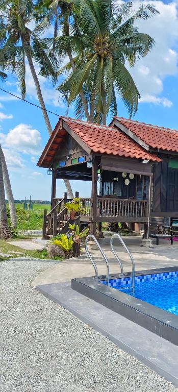 PenagaにあるKampung Cheq Homestay - Private Pool, Free Wifi, Netflixのリゾート(建物の隣にスイミングプールあり)