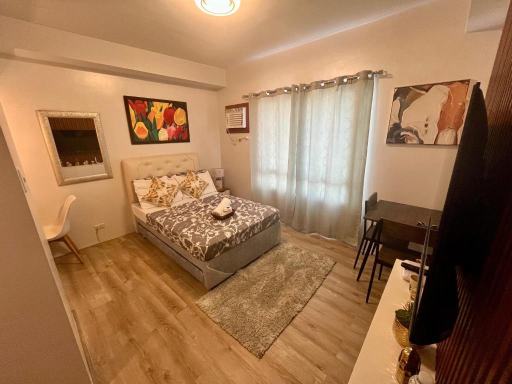 a small bedroom with a bed and a desk at Mesavirre Garden Residence in Bacolod