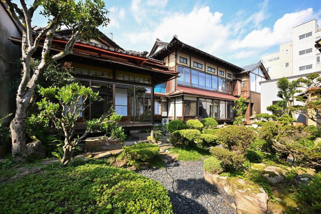 una casa con un jardín delante de ella en Hideaway Tabaki en Echizen