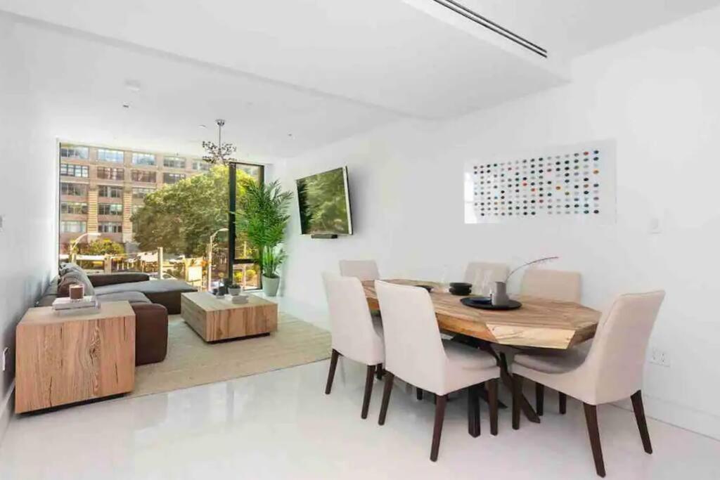 a dining room with a wooden table and white chairs at Luxurious Soho Apartment~ 2 Bedroom 2 Bathroom in New York