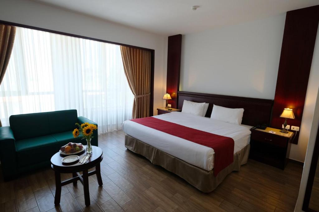 a hotel room with a bed and a blue couch at City Inn Palace Hotel in Ramallah