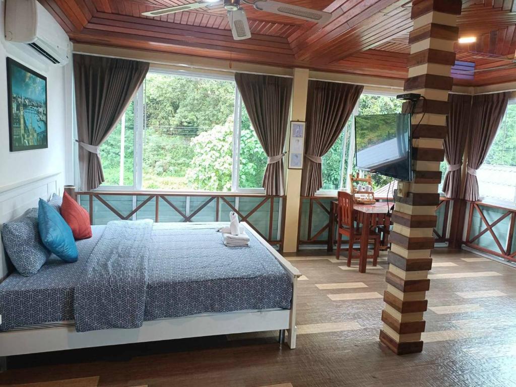a bedroom with a bed and a flat screen tv at Mountain View Guest House in Phatthalung