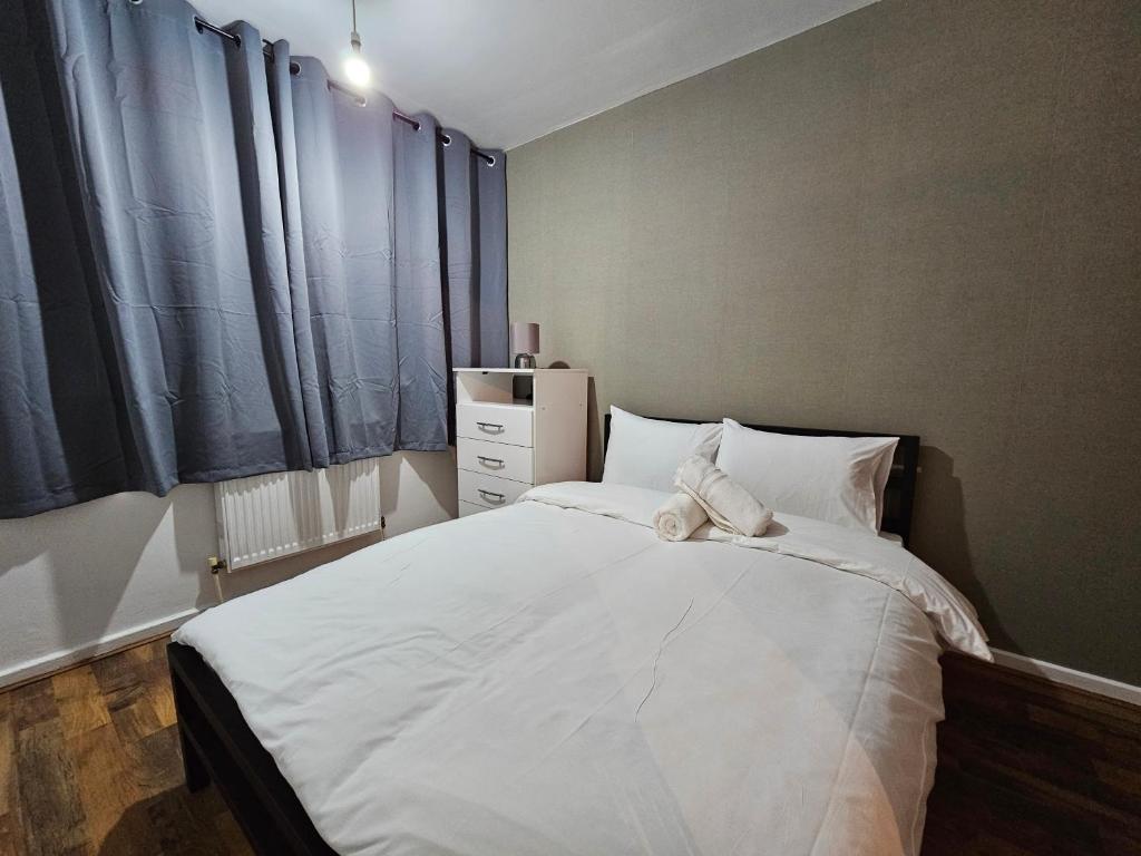 a bedroom with a bed with a teddy bear on it at Spitalfields Rooms in London