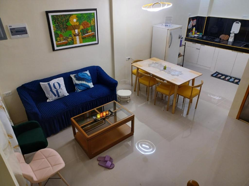 ein Wohnzimmer mit einem blauen Sofa und einem Tisch in der Unterkunft Cebu City 80sq Apartment near SM Seaside NuStar Ocean Park Dynamic Herb in San Roque