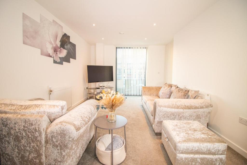 uma sala de estar com dois sofás e uma televisão em Cosy 1Bedroom Apartment in Greenwich Cutty Sark em Londres
