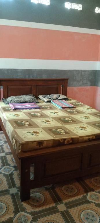 a bed sitting in a room next to a wall at Dino Enjoy Property in Trincomalee