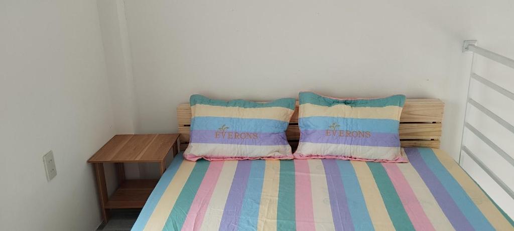 a small bedroom with a bed with two pillows at Vibi motel Hòn Rơm in Phan Thiet