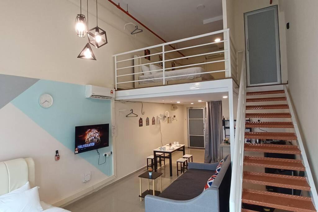 une pièce avec un escalier et une salle à manger avec une table dans l'établissement Grand Suite @ The CEO Penang, à Bayan Lepas