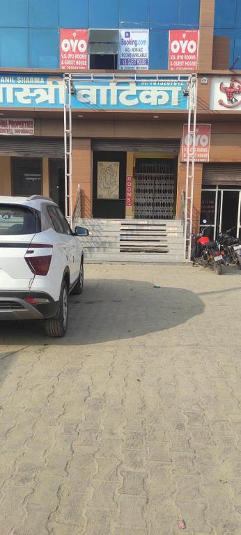 une voiture blanche garée devant un bâtiment dans l'établissement V.S guest houes, à Palwal