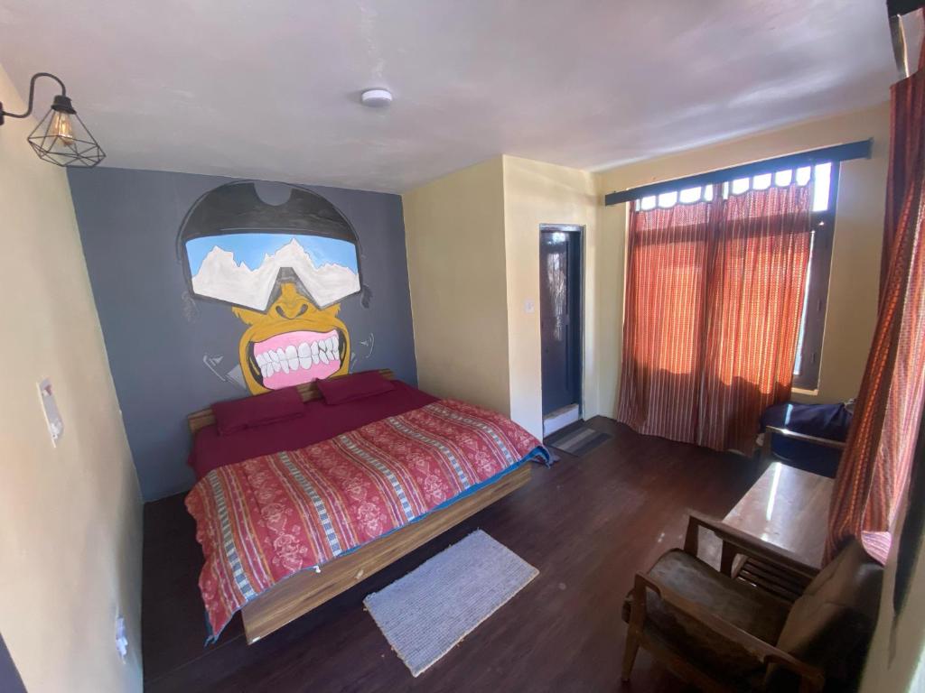 a bedroom with a bed with a painting on the wall at Krishna Guesthouse by AttiC Monkey, Old manali next to Drifters cafe in Manāli