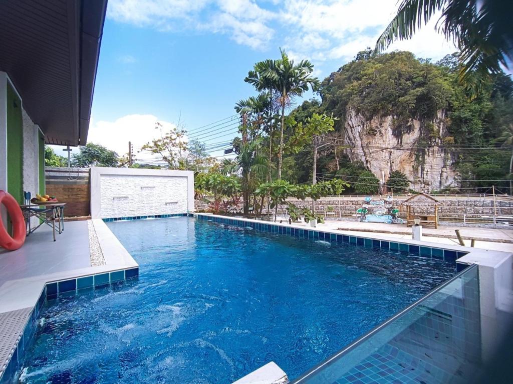 a large swimming pool with a mountain in the background at Krabi River Cottage Pool Villa in Ban Krabi Yai
