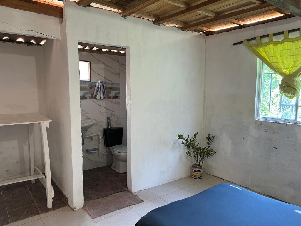 a room with a bathroom with a toilet and a window at Punta Arena EcoHostal & EcoFit - Your Eco-Friendly Oasis 01 in Playa Punta Arena