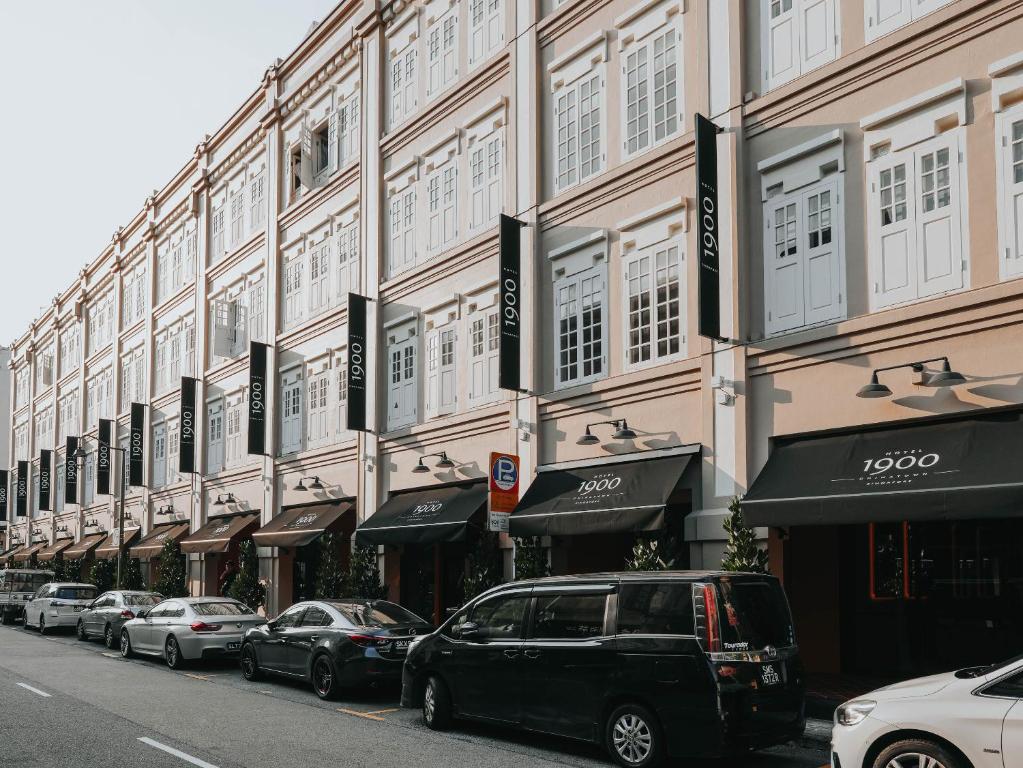 uma fila de carros estacionados em frente a um edifício em Hotel 1900 Express Chinatown em Singapura