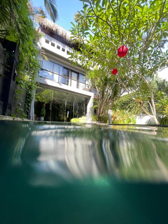 Balian的住宿－SURFLAB VILLA，树上有一朵红花的建筑